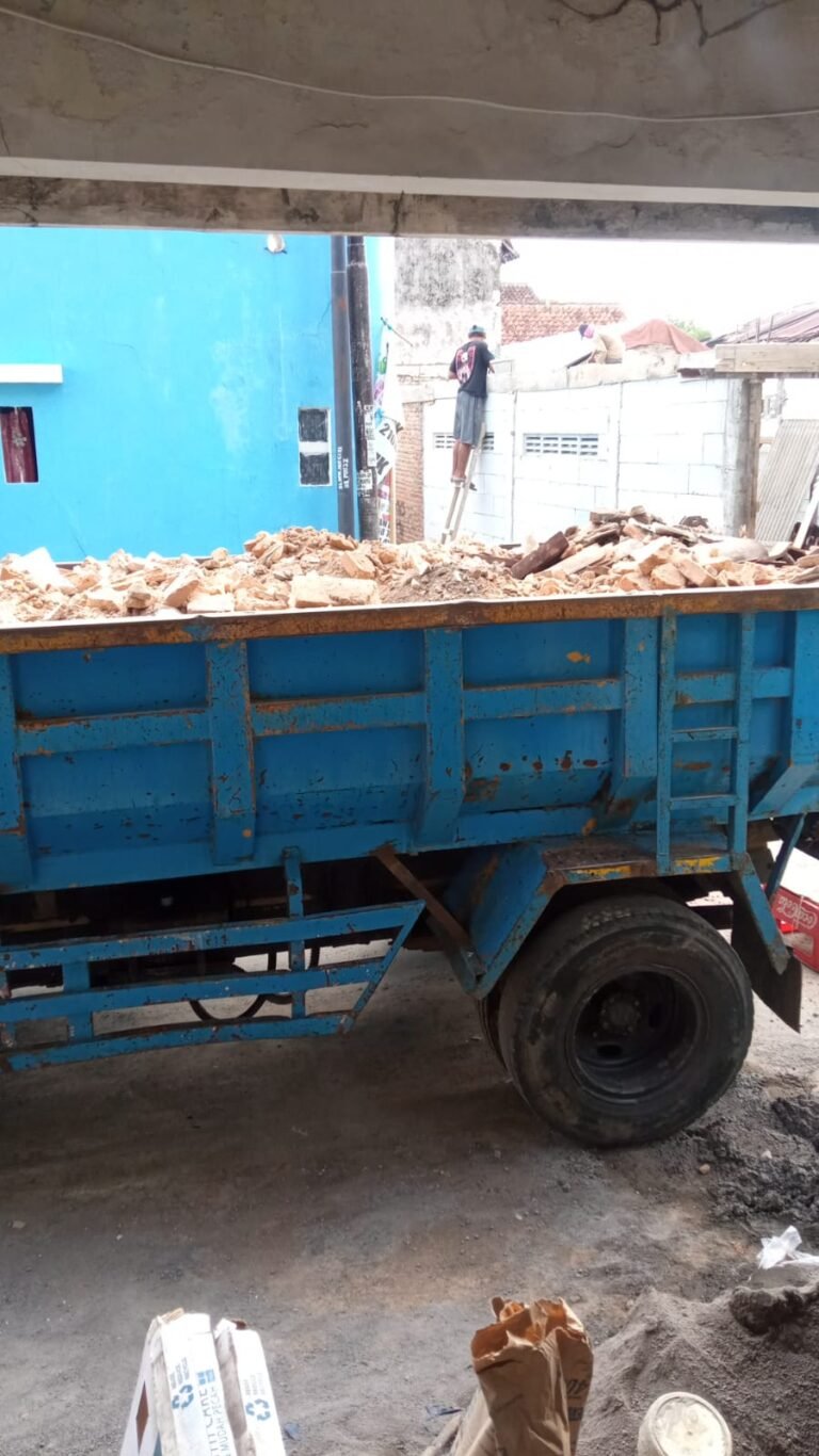 Tim profesional sedang memuat sampah proyek dari situs konstruksi di Jogja ke dalam kontainer khusus